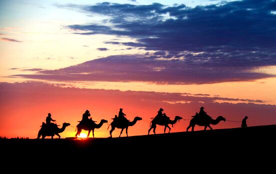 敦煌是古代絲綢之路上的重鎮，歷史上東西方文化交匯的重要樞紐。圖為鳴沙山月牙泉景區的沙漠駝隊。