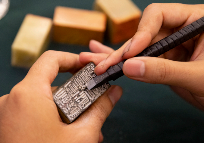 2023年10月18日，華東師范大學書法篆刻專業的學生在現場篆刻。當 天，華東師范大學“大夏百詠”篆刻創作啟動暨韓天衡獎學金頒發儀式舉行。 “大夏百詠”篆刻創作項目是2023—2024年華東師范大學校園文化重點項 目，旨在傳承文脈，彰顯底蘊。