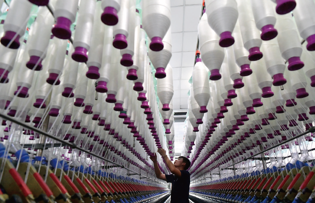 2024年7月17日，位于福州市長樂區的福建金源紡織5G智 慧工廠里，工人在生產線上作業。