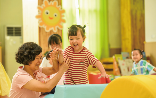 近年來，各地著力解決3歲以下嬰幼兒家庭入托難、入托貴等 問題，大力發展完善普惠托育服務體系，不斷增強人民群眾對普惠 托育服務的獲得感和滿意度，促進嬰幼兒健康成長。圖為2024年 9月4日，江西省奉新縣示范幼兒園托育班的老師和孩子們在快樂 地玩耍。